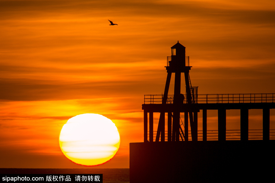 英國(guó)惠特比碼頭日出風(fēng)光 燈塔影影綽綽景色美